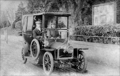 04TM03_03_2
Bill comes from Wiltshire. His father, shown here c.1910 driving this splendid car, was an under-coachman. He became a chauffeur when the motor car started to replace horse drawn coaches. After the Great War he went into farming. 

From Bill Mayell
