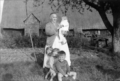 07_4DE004_3
Mrs Hariet Hart Inch (nee Nichols) wife of Albert Inch. Photo taken in front of barn in Burley Lane. Now believed to be Tidrock House, home of William Bishop. For names of the children see previous picture. 

From David Pink
