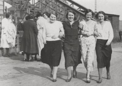 09PO034_3_2
Mill girls leaving Portals via the railway footbridge at the station. Note the person on the left collecting the overalls. L to R : Rose Reading, Eileen Hodgkinson nee Switzer, Margaret Baker and Jean Bond nee Switzer. 

From Layton Bond
