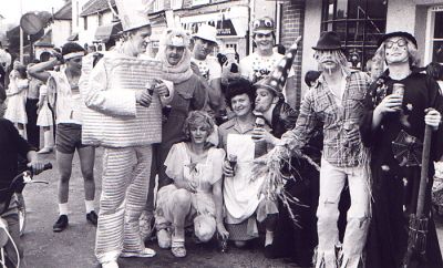 15_1OC002_03_04
This was taken at the wheelbarrow race in the late 1970s / early '80s - David Pyle in shorts; Ray Web is Tin Man; Denny McCann is the Lion; Dean Stickland is behind Denny; Darren Tilbury is in the corner; the one in the middle kneeling is Roy Banning; the scarecrow is Nigel Williams; and the witch is thought to be Jim Fletcher. They are all outside what is now Caviste in Winchester Street. 

Photo from Janice Stott
